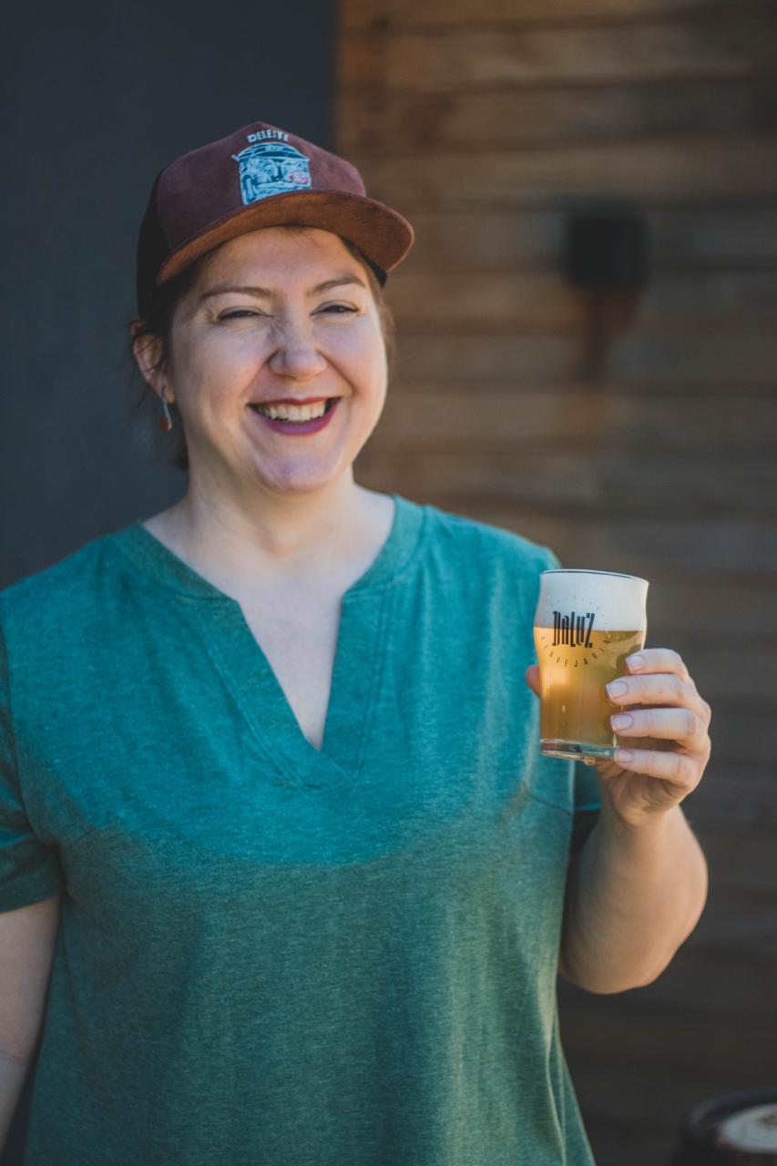 Proprietária com um copo de cerveja na mão